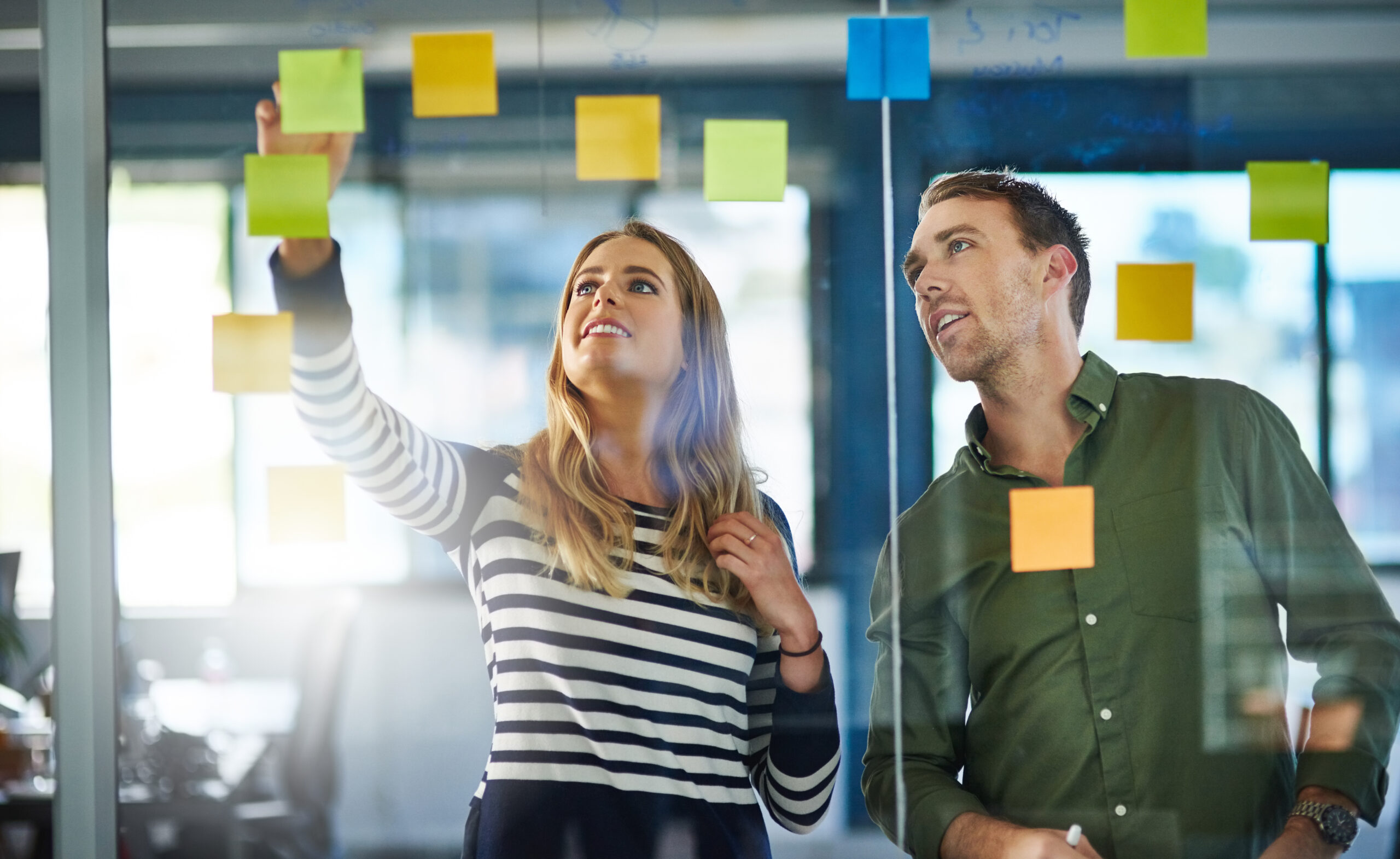 Shot of colleagues having a brainstorming session with sticky notes at work